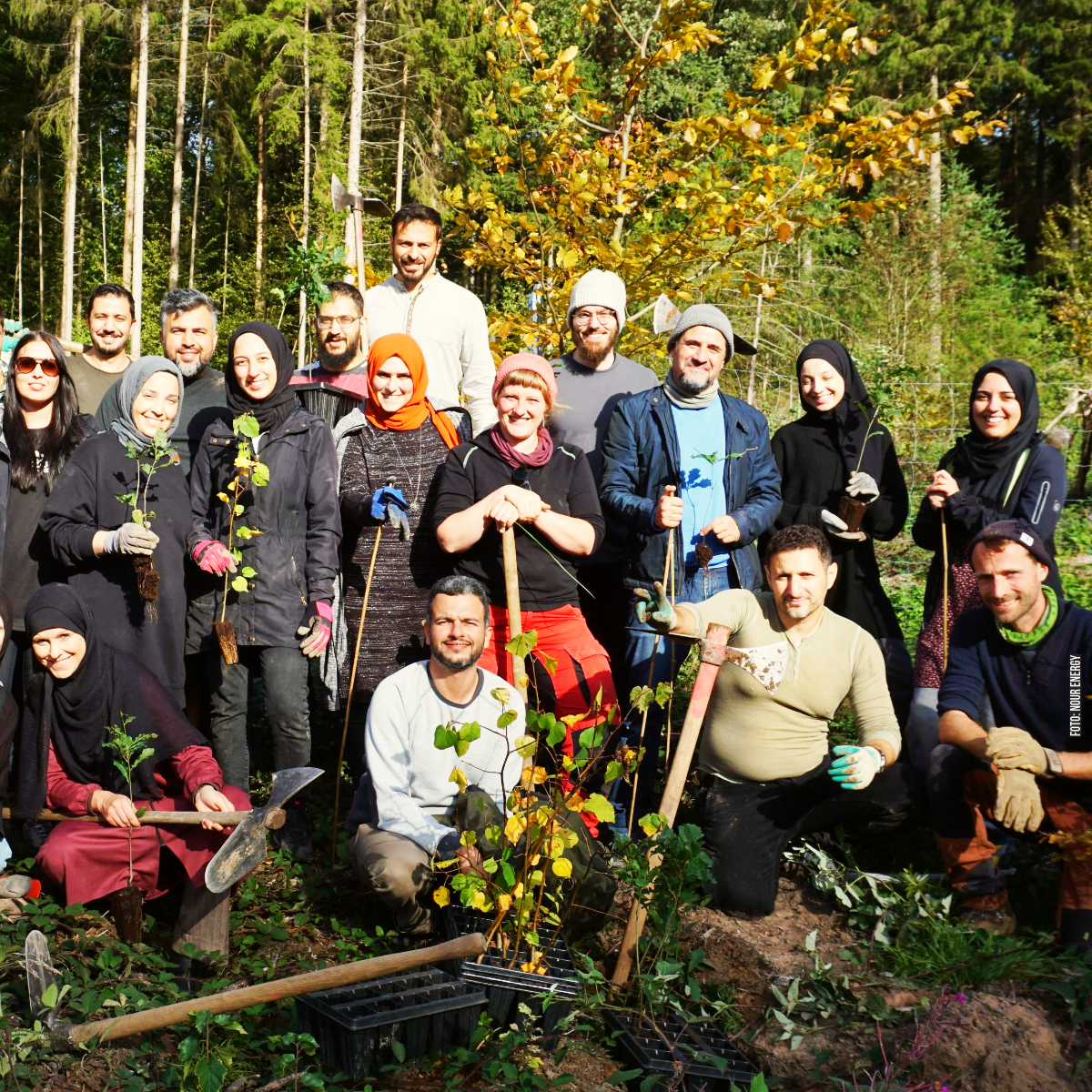 Menschen im Wald Gruppe von Menschen im Wald mit Setzlingen und Werkzeug, manche tragen Kopftuch oder Mütze