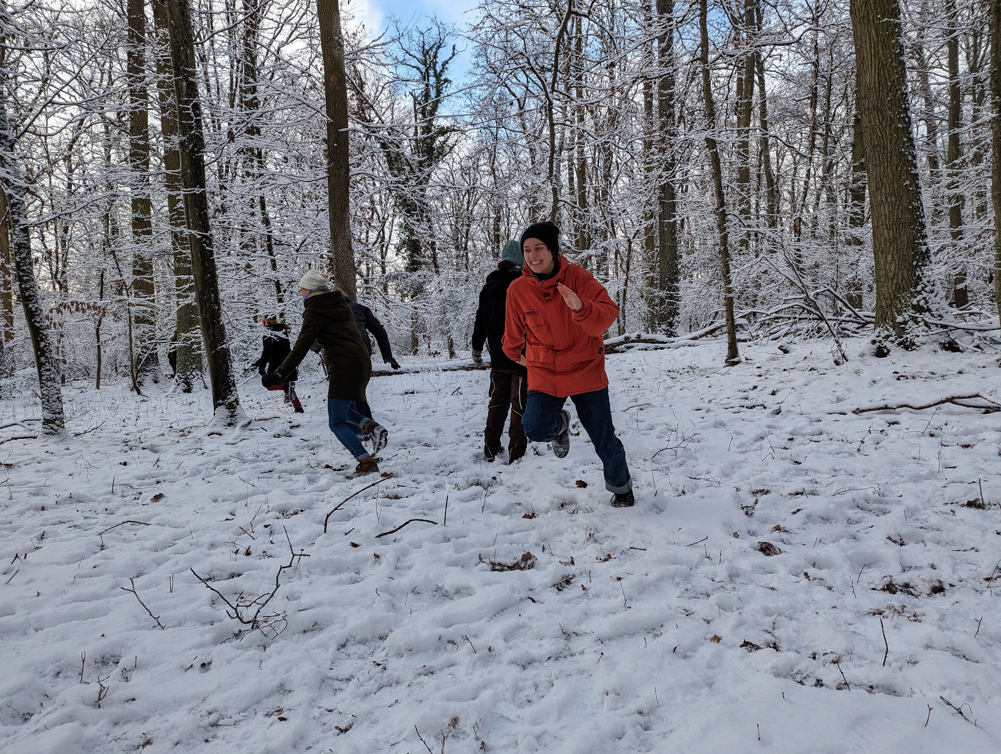Spiele spielen Mehrere Personen spielen ein Spiel im verschneidten Winterwald