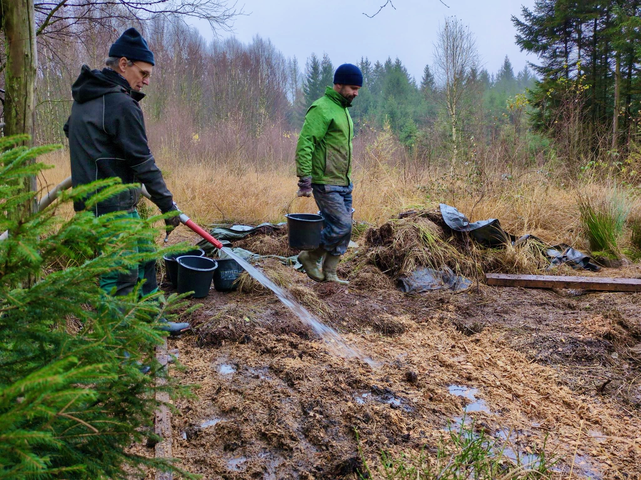 Wasser marsch! Wasser wird auf die Grabenverfüllung aus Sägemehl-Hackschnitzel gespritzt