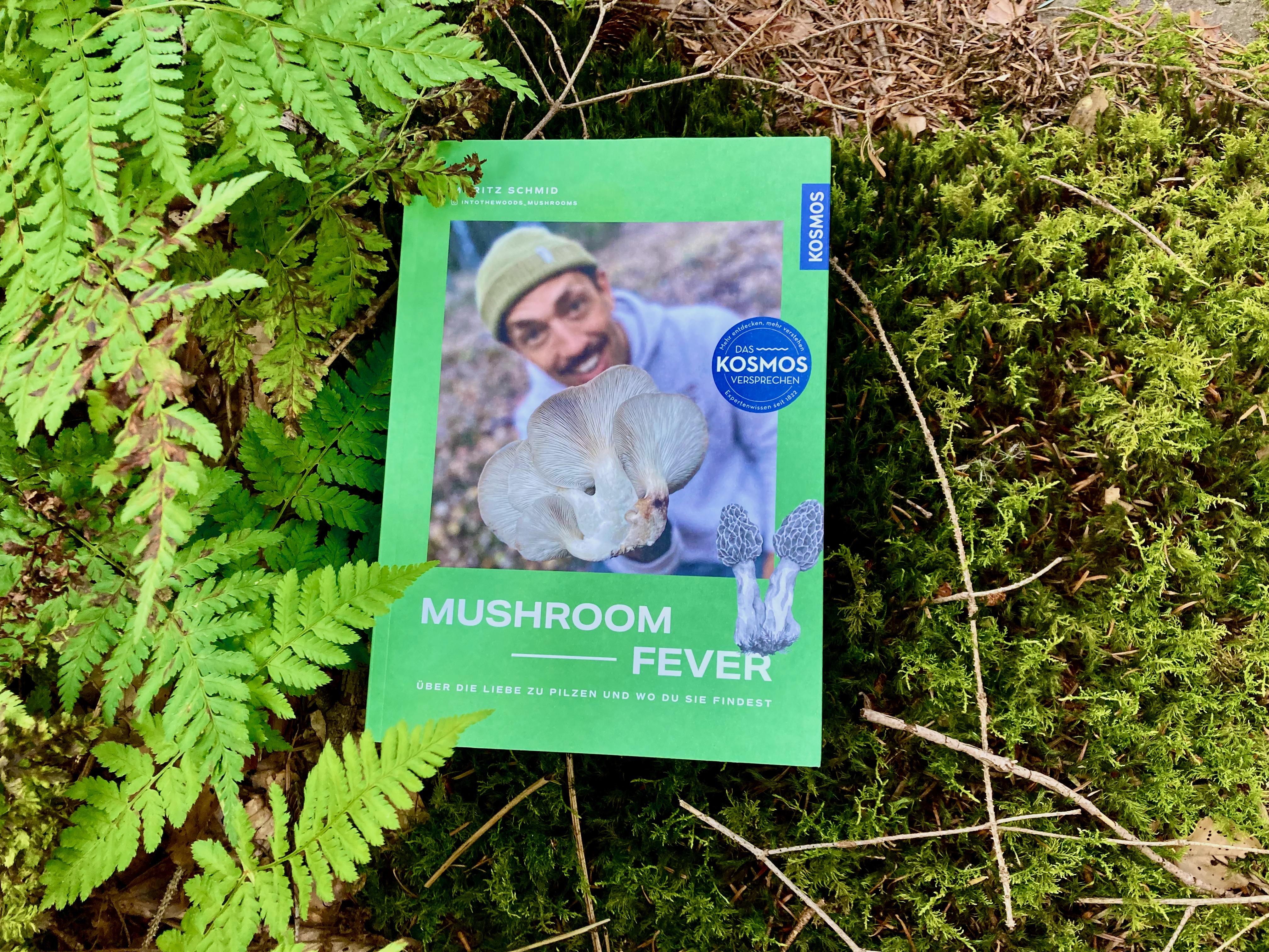 Buch Mushroom Fever liegt zwischen Moos und Farn