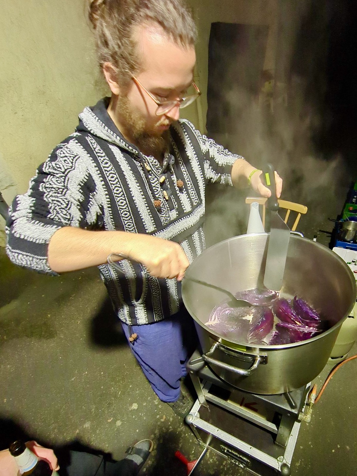 Mann schmort Blaukrautspalten in Miso in große Topf