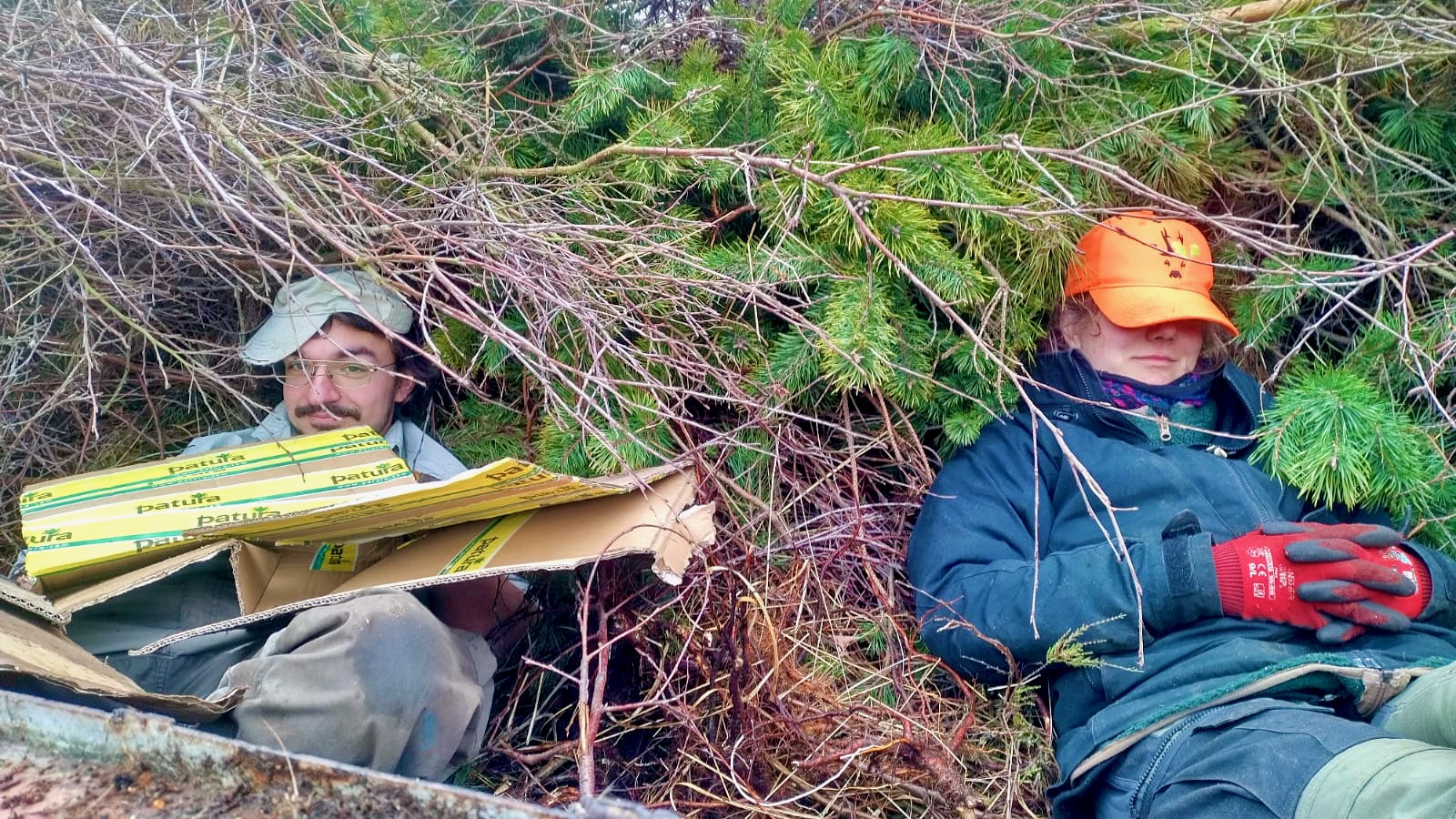 Pausi im Schnittgut Freiwillige sind erschöpft und ruhen sich in Schnittguthaufen aus