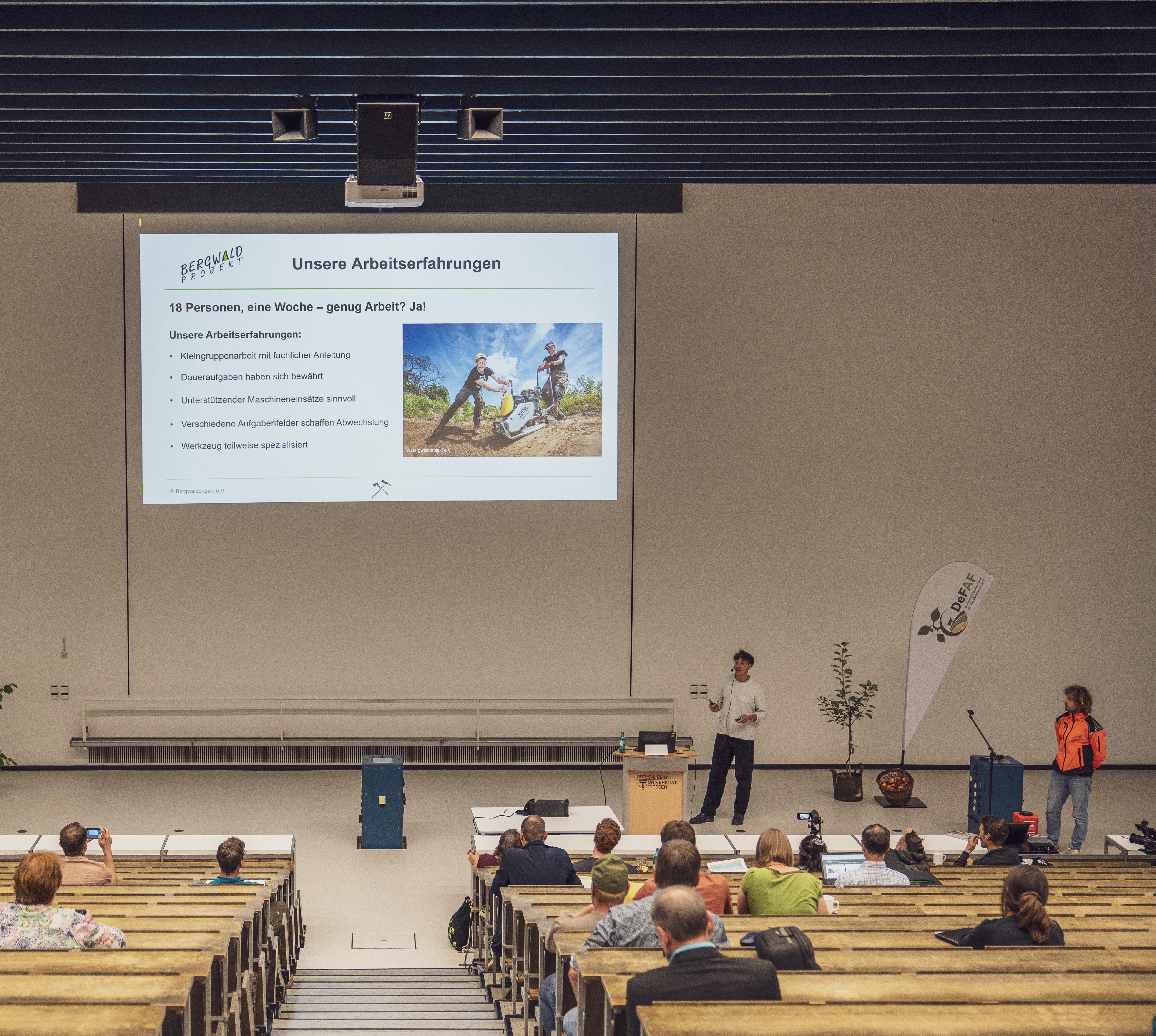 zwei Personen halten einen Vortrag in einem Hörsaal