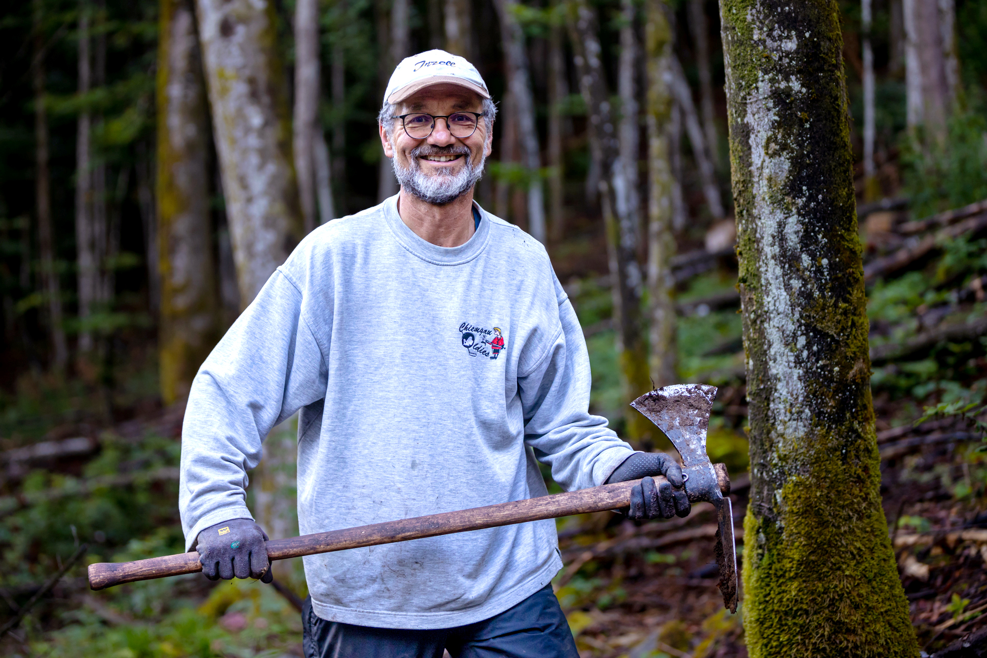 Lächelnder Teilnehmer mit Wiedehopfhaue in den Händen