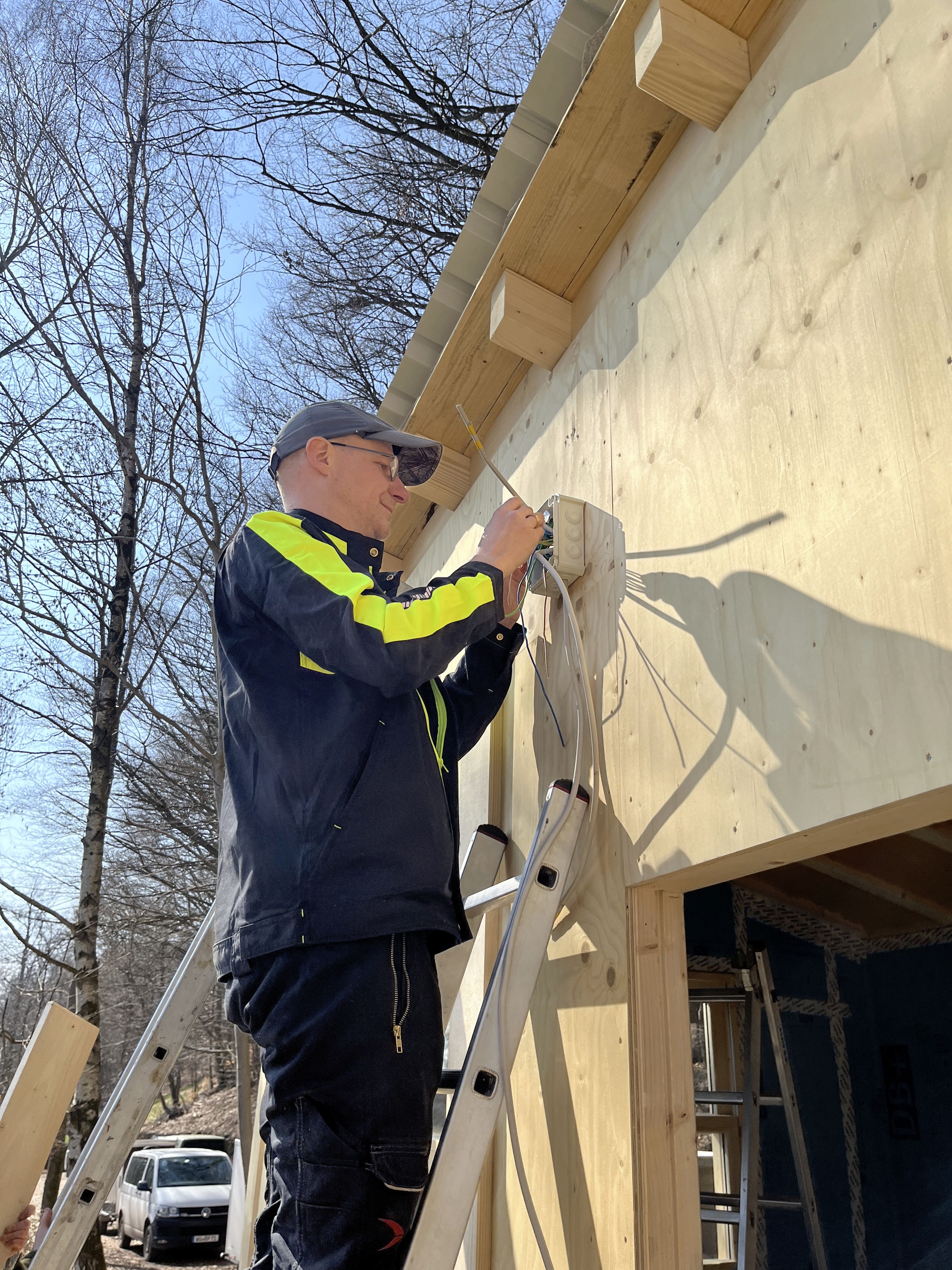Person mit schraubt eine Schraube in Outdoor-Campküchen-Wand