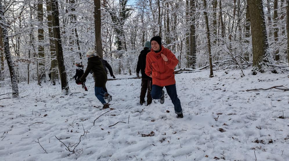 Menschen im Wald spielen ein Spiel bei Schnee