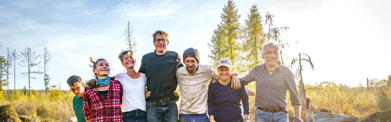 Fröhliche Freiwillige beim Stampfen im Moor