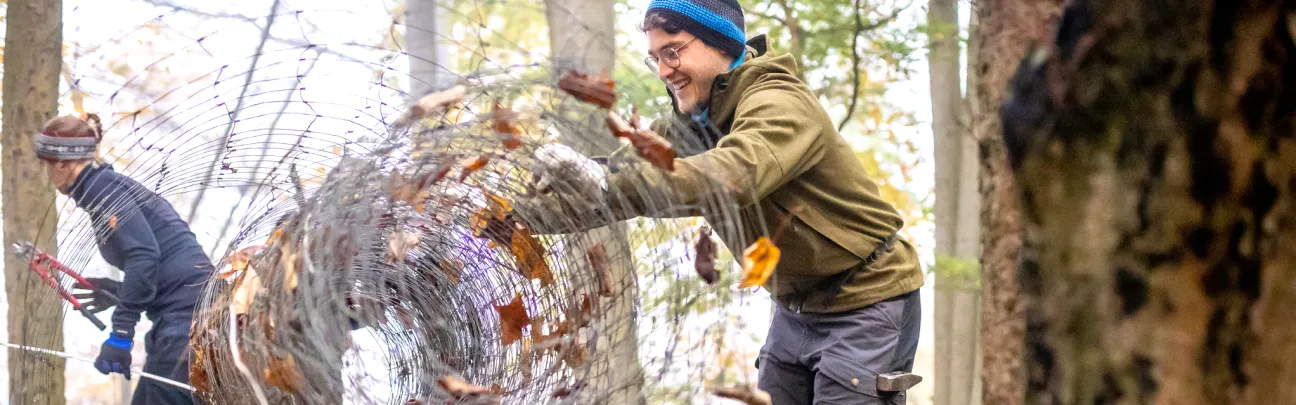 Junger Teilnehmer rollt abgebauten Zaun zusammen