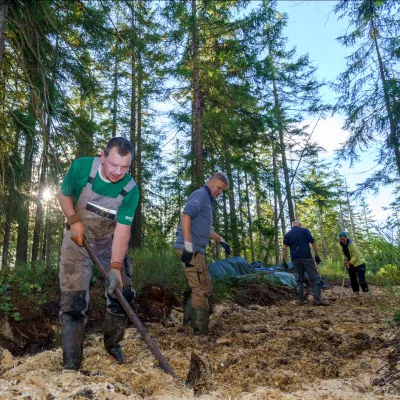Teilnehmende beim Verfüllen des Grabens