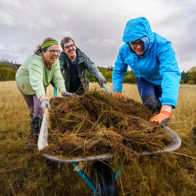 BWP_Freiwilligenprojekte_Integrative Wochen_NP Kellerwald.jpg 3 Menschen schieben beladene Schubkarre
