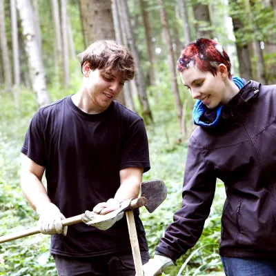 Junger Mann und Frau mit Pflanzwerkzeugen