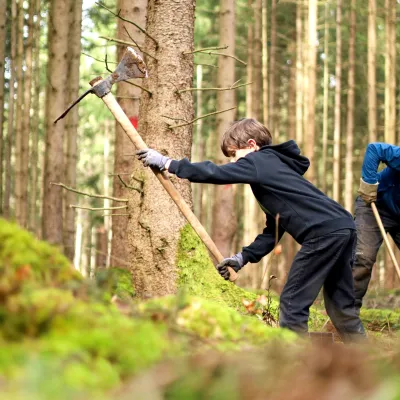 Junge mit Wiedehopfhaue bei der Pflanzung