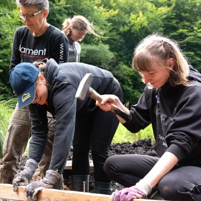 Mehrere Teilnehmende beim Anbringen einer Spundwand