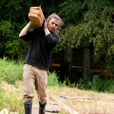 Mann trägt Bretter zur Arbeitsstelle