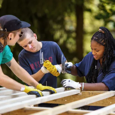 Gruppe von Schülern bauen ein Hordengatter zusammen