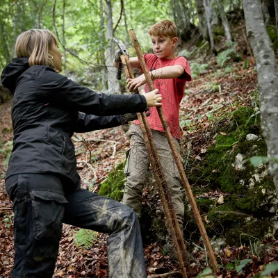 Schüler bringen Verbissschutz an Setzling an