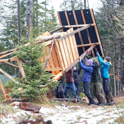 Teilnehmende richten gemeinsam einen neuen Hochsitz auf