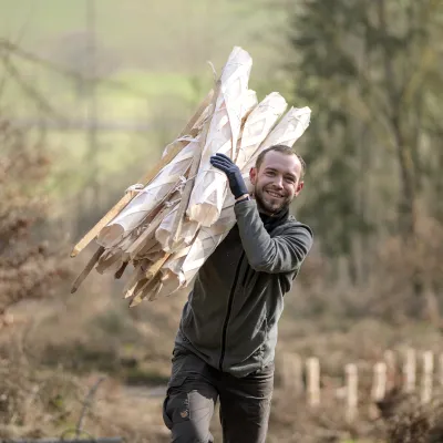 Lächelnder Teilnehmer trägt Holzbohlen