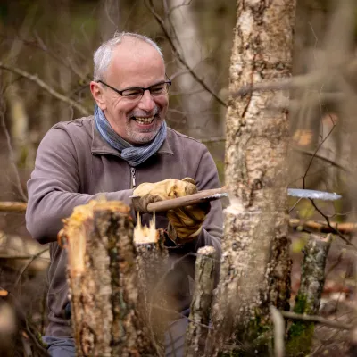 Lächelnder Teilnehmer sägt einen Baum