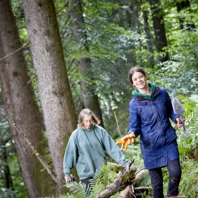 Zwei Teilnehmerinnen laufen lachend durch den Wald