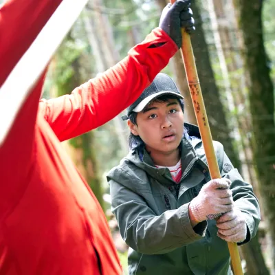 Zwei Teilnehmer bringen einen Stab in den Boden