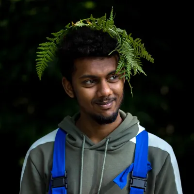Portrait eines Teilnehmers mit Farn auf dem Kopf