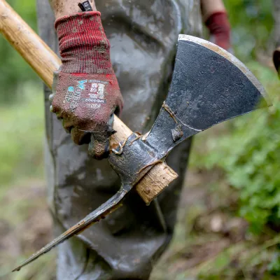 Nahaufnahme einer Hand die eine Wiedehopfhaue hält