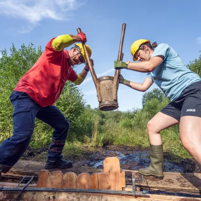 Zwei Teilnehmende bei der Arbeit mit der Rammkatze