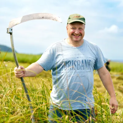 Lächelnder Teilnehmer mit einer Sense