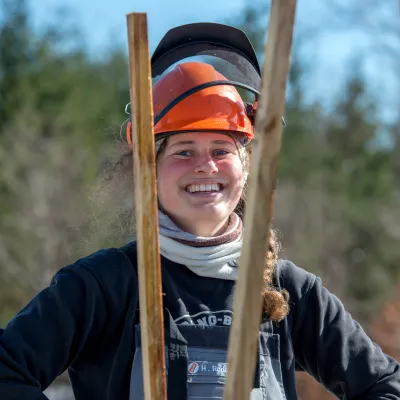 Portrait einer lachenden Frau mit Schutzhelm