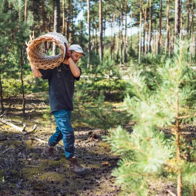 Teilnehmer trägt aufgerollten Zaun zur Arbeitsstelle