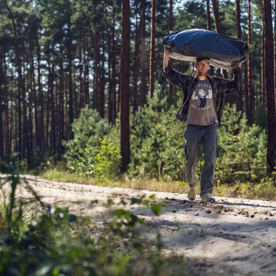 Teilnehmer trägt Materialien auf dem Kopf zur Arbeitsstelle