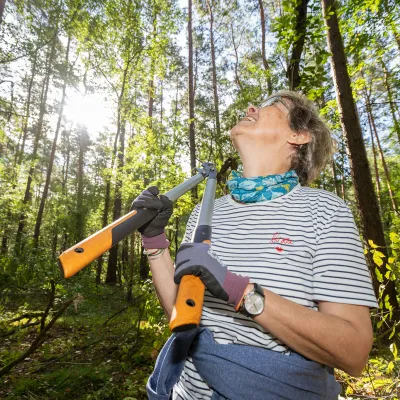 Frau mit Astschere im Wald