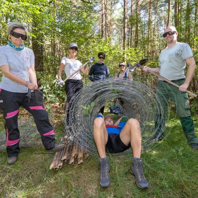 Gruppe mit aufgerolltem zaun udn Werkzeugen