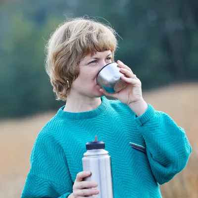 Frau trinkt aus dem Thermobecher