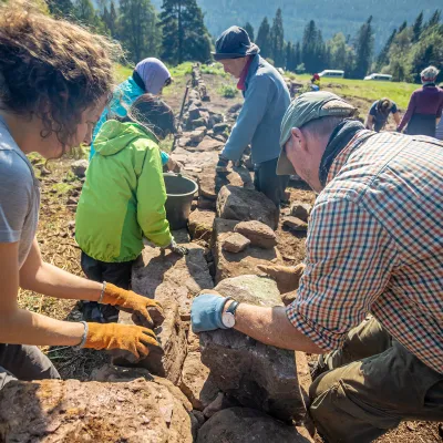 Gruppe baut Trockensteinmauer