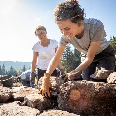 Frauen setzen Trockensteinmauer im Gegenlicht