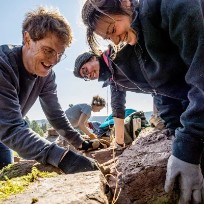 lachende Gruppe baut Trockensteinmauer