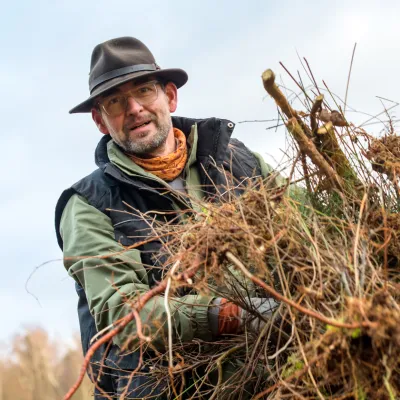 Teilnehmer mit Hut beim Abtransport von Grünschnitt