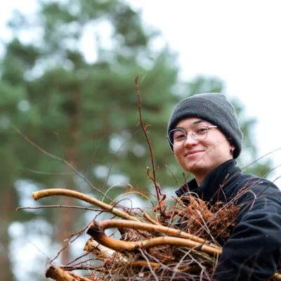 Lächelnde Teilnehmerin beim Abtransport von Ästen