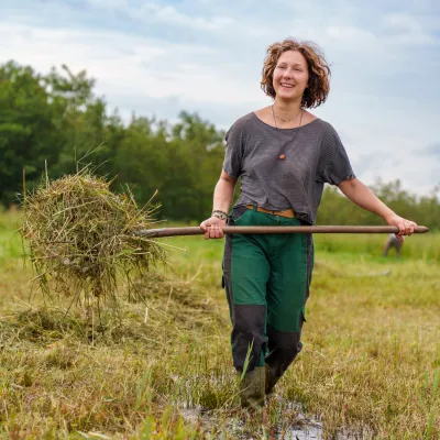 Lächelnde Teilnehmerin bei der Mahd