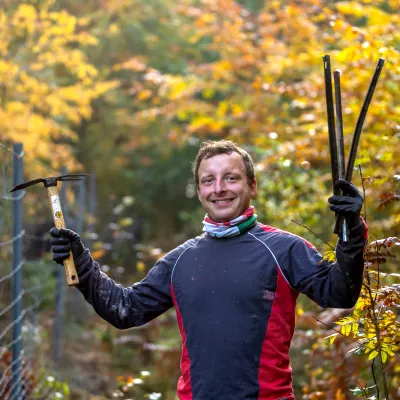 Lächelnder Teilnehmer hält Werkzeuge hoch