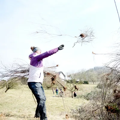 Teilnehmerin wirft Schnittgut auf einen Haufen
