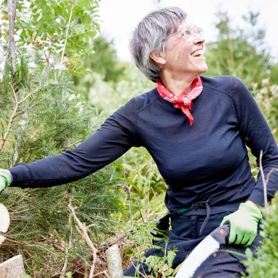 Lachende Teilnehmerin mit Astsäge bei der Gehölzentnahme