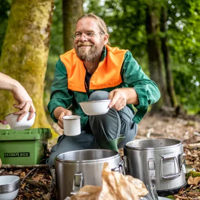 Lächelnder Teilnehmer bei der Ausgabe des Mittagessens