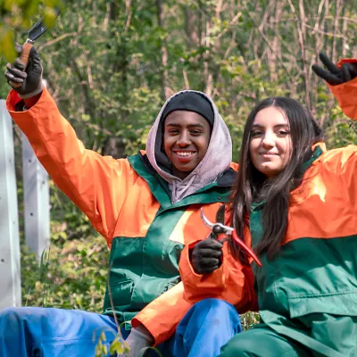 Teilnehmer und Teilnehmerin lächeln in die Kamera