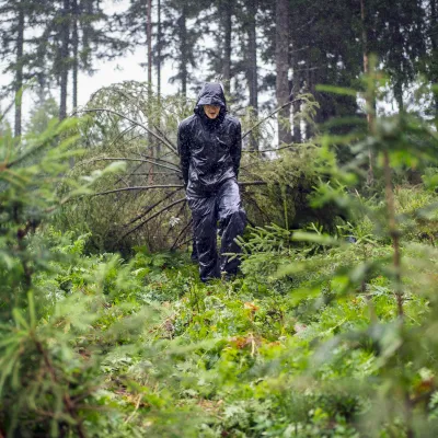 Teilnehmerin mit Regenjacke beim Abtransport von Zweigen