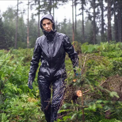 Teilnehmerin mit Regenjacke beim Abtransport von Zweigen