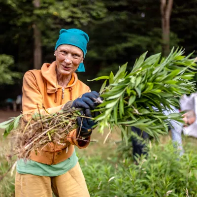Lächelnde Teilnehmerin bei der Entnahme von Gehölzen