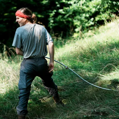 Teilnehmerin freut sich bei der Mahd mit der Sense